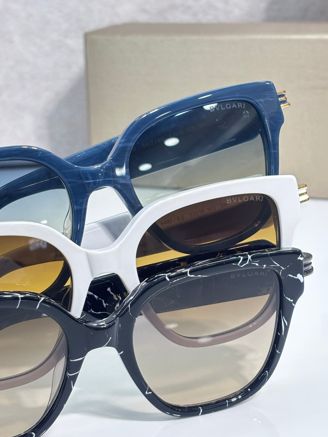 White and blue square sunglasses with tinted lenses and gold-tone temple details