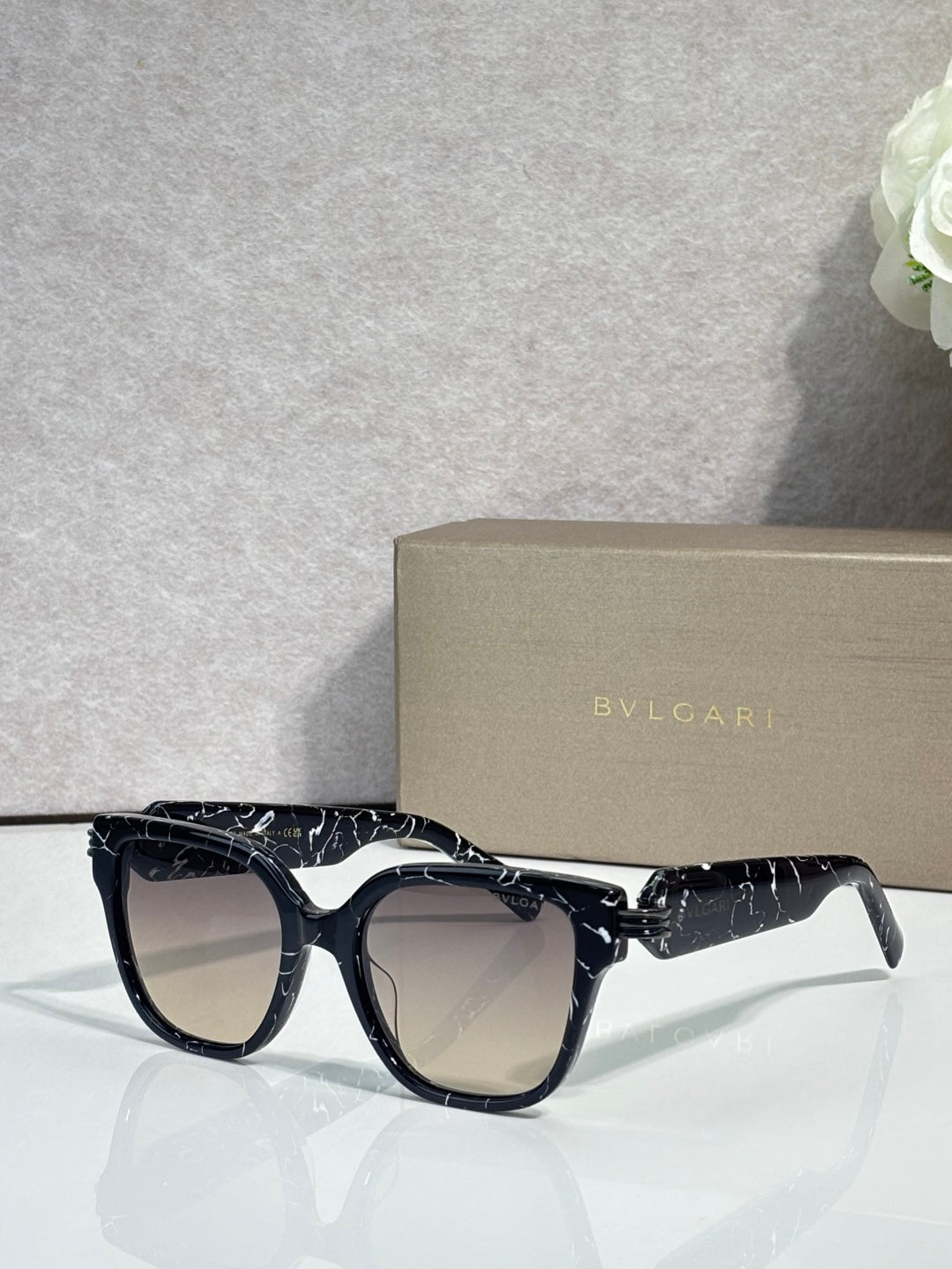 Black patterned square sunglasses with dark lenses and BVLGARI logo on temples