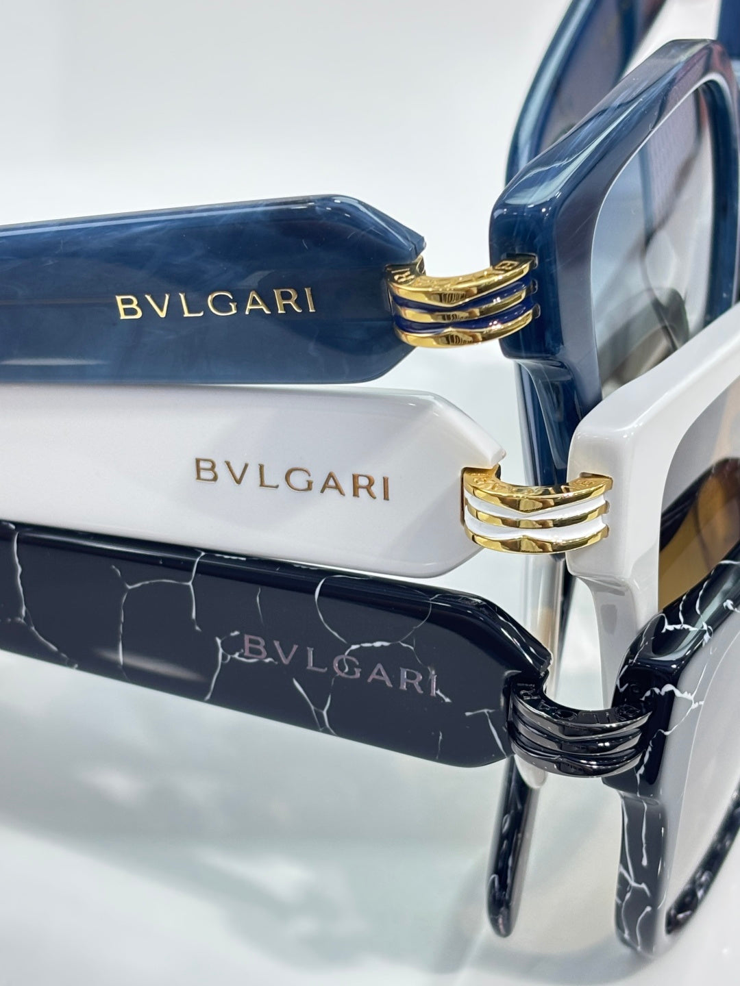 Blue sunglasses with gold stacked-buckle temple detail and BVLGARI logo on arms