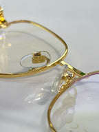 Gucci eyeglasses arm close-up with gold metal and logo hardware on clear lens
