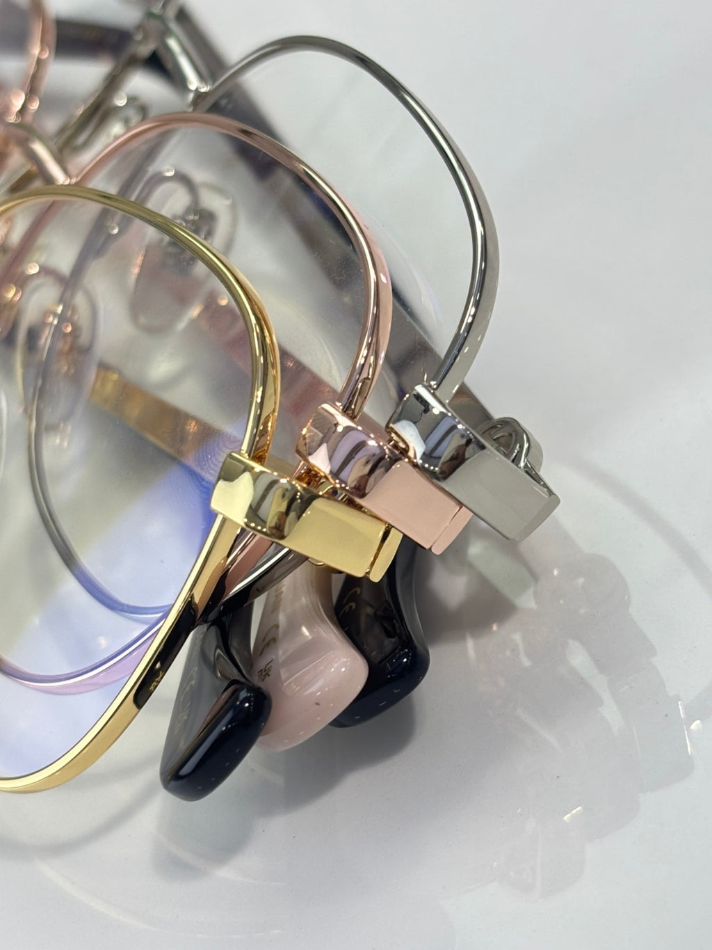 Metal eyeglasses temples with clear lenses in silver, gold, and dark accents