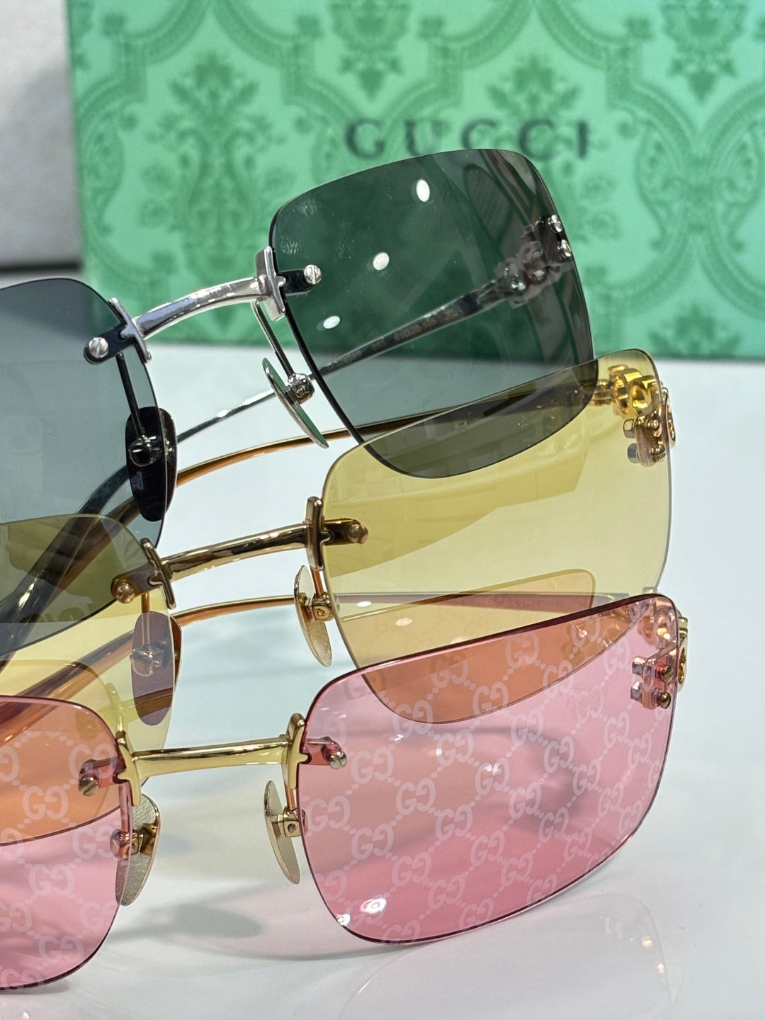 Sunglasses set with green, yellow, and pink-tinted lenses on gold frames