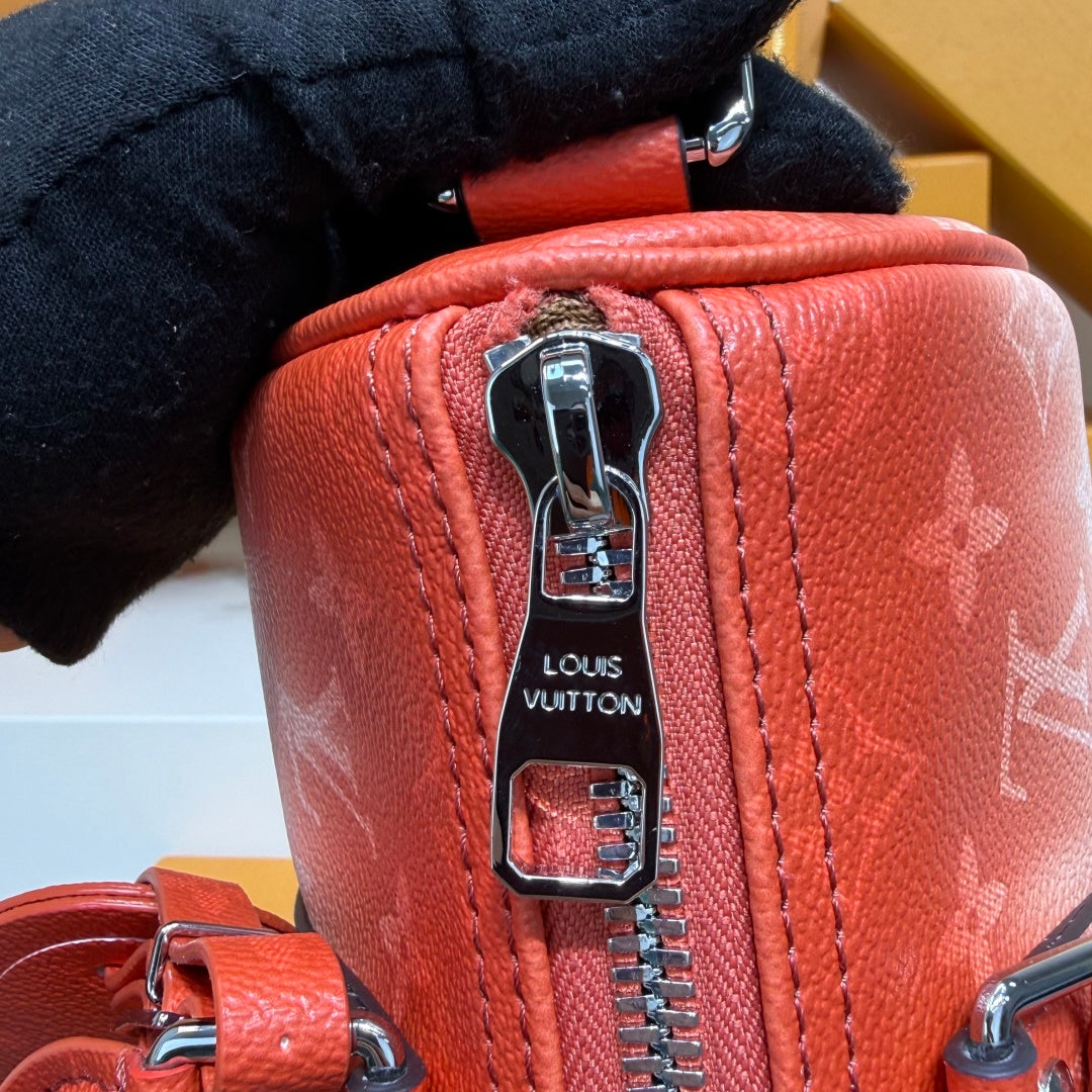 Louis Vuitton red leather handbag close-up with silver zipper pull and hardware