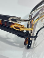 Cartier glasses close-up of dark blue and gold temples, clear lenses