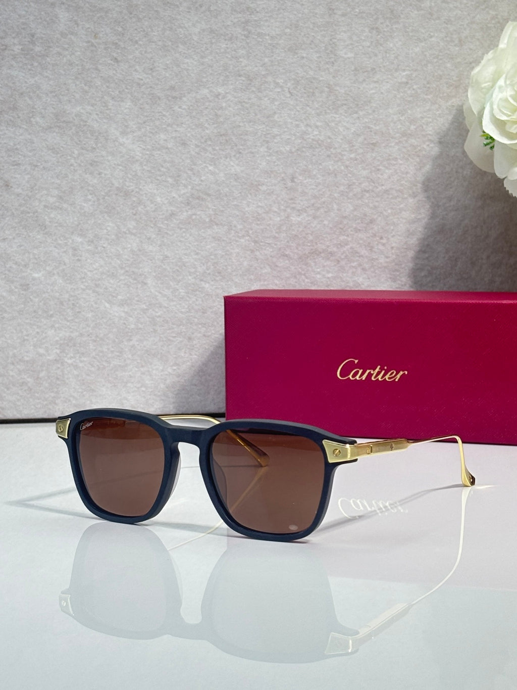 Blue eyeglasses with brown-tinted lenses, square frames, and gold-tone temple accents.