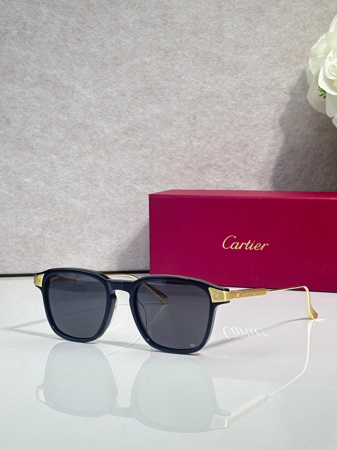 Blue eyeglasses with dark lenses, square frames, and gold-tone metal temple details.