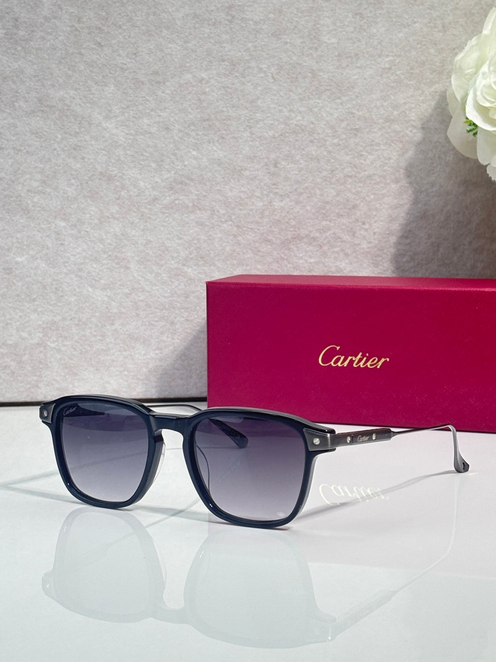 Navy eyeglasses with dark lenses, square frames, and gold-tone hinge accents.