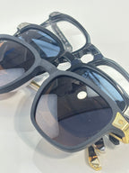 Overhead view of dark navy eyeglasses with tinted lenses and gold-tone temple accents.