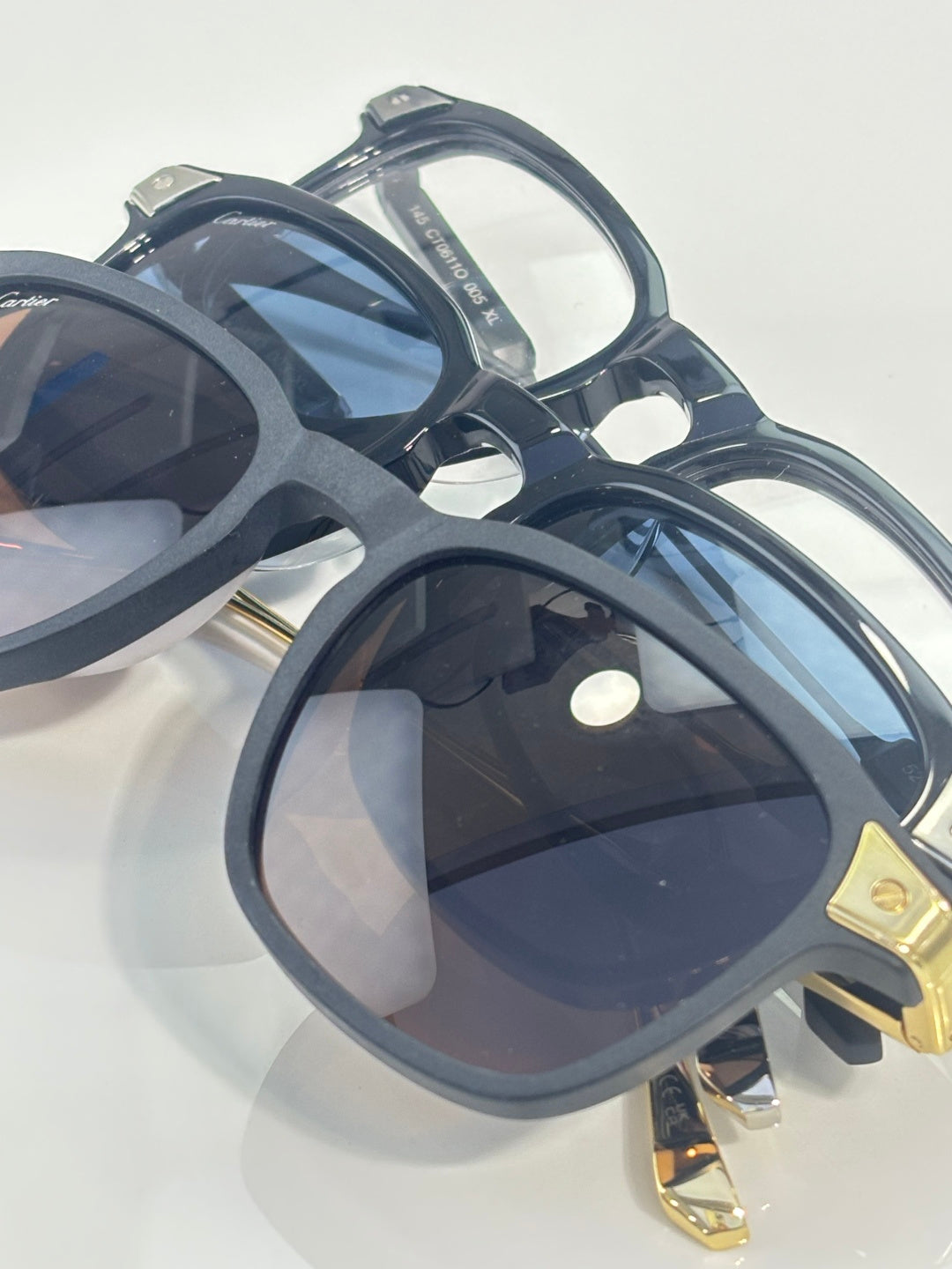 Overhead view of dark navy eyeglasses with tinted lenses and gold-tone temple accents.