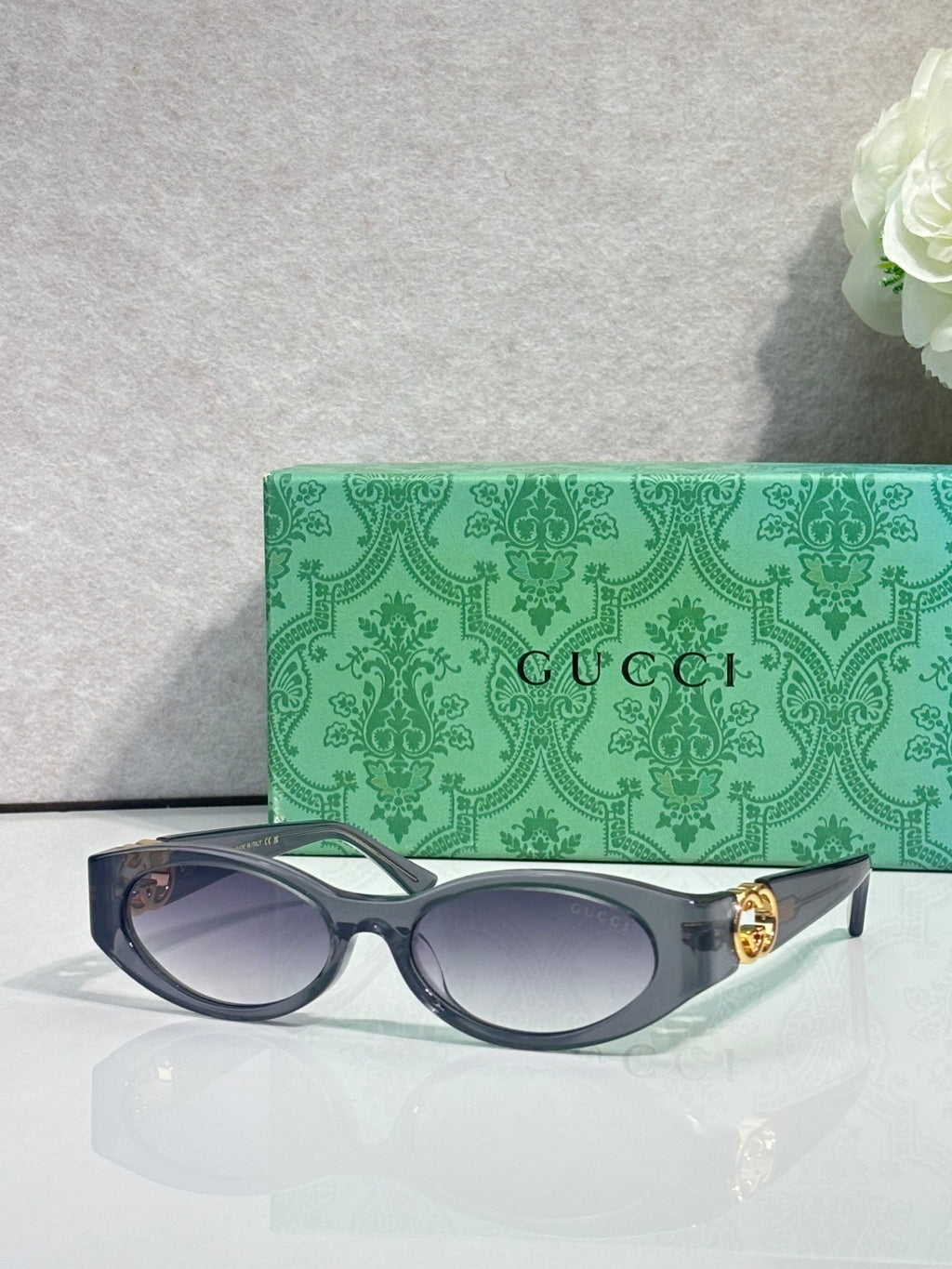 Gucci cat-eye sunglasses with dark frames and clear lenses, gold logo detail