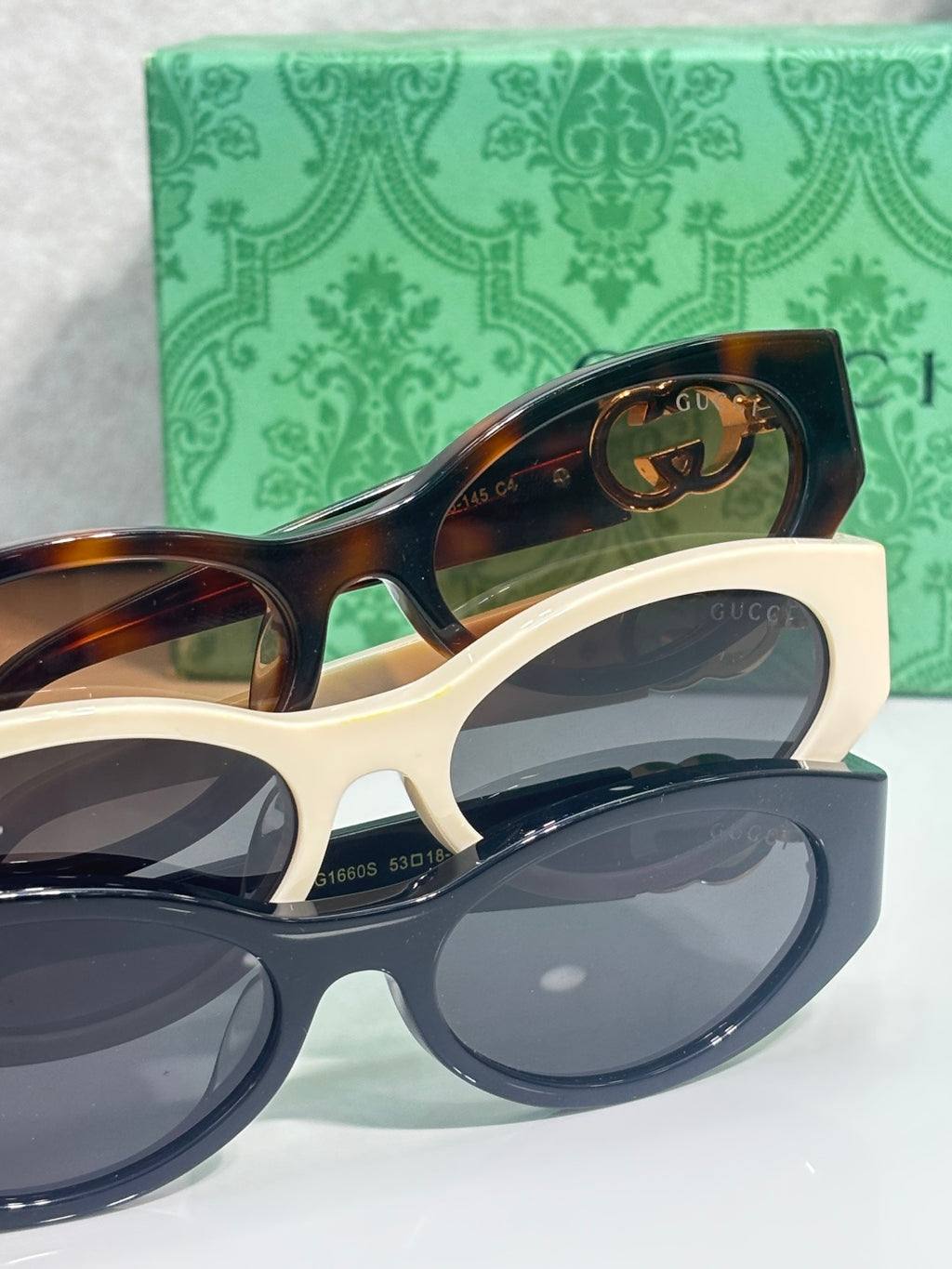 Gucci sunglasses front view with dark tortoiseshell frames, navy lenses, and gold logo