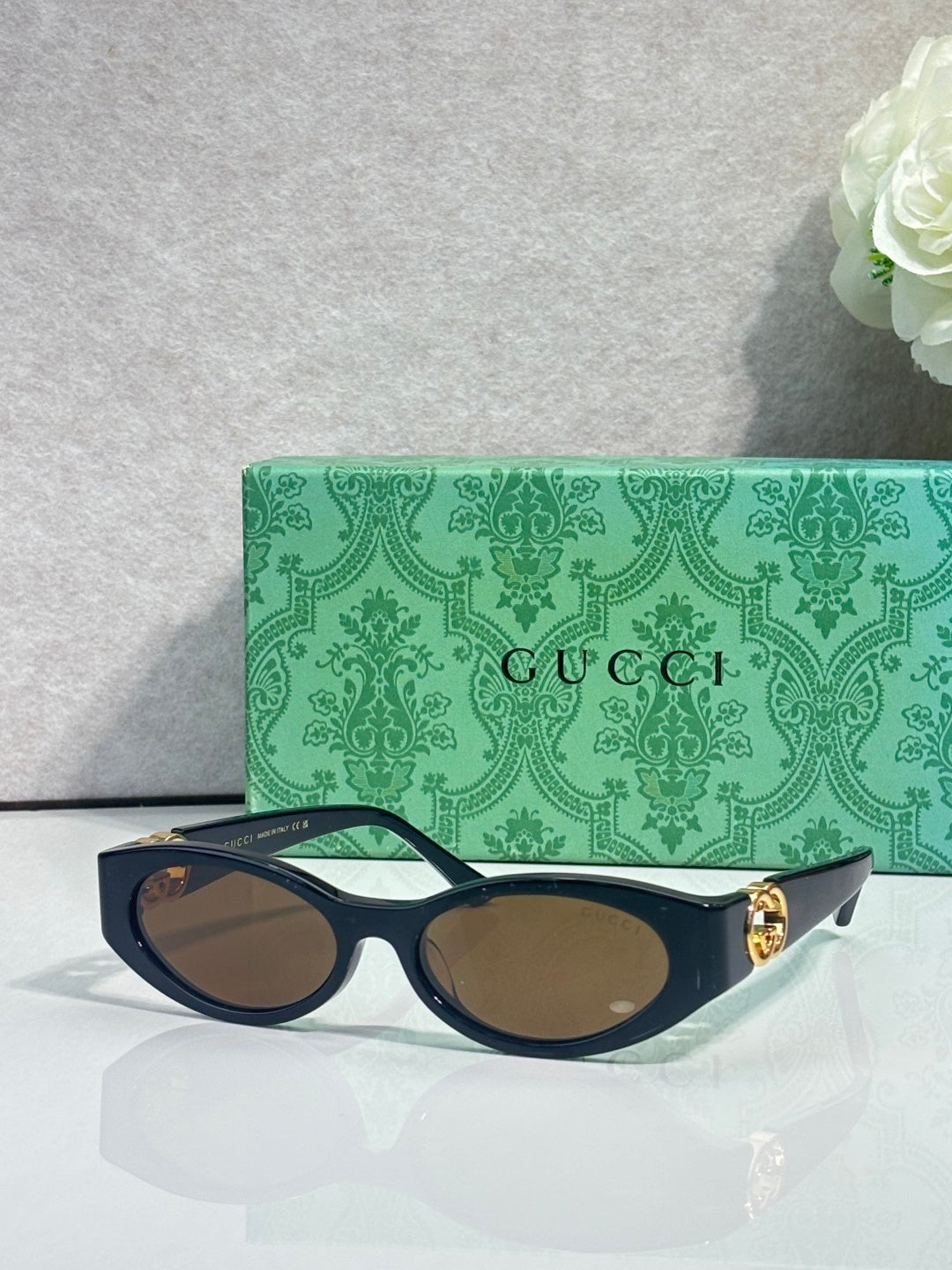 Gucci cat-eye sunglasses with dark frames, tinted lenses, and gold logo detail