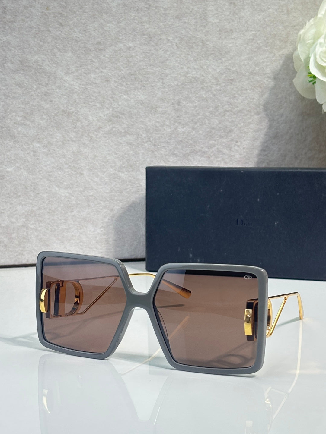 Sunglasses with dark blue square frames and brown tinted lenses