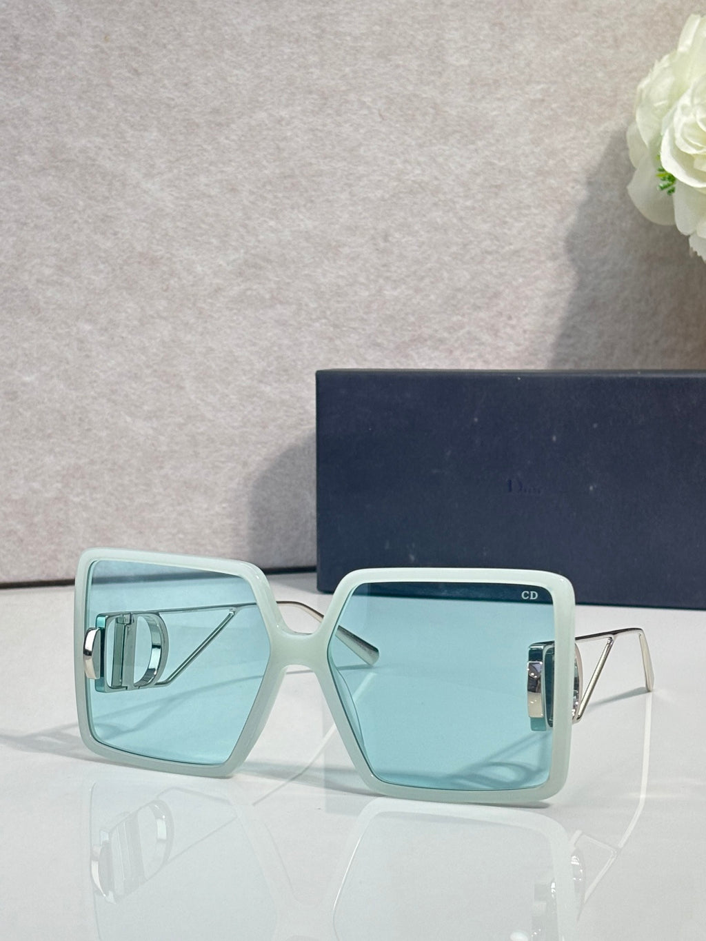 Sunglasses with light blue square frames and blue tinted lenses