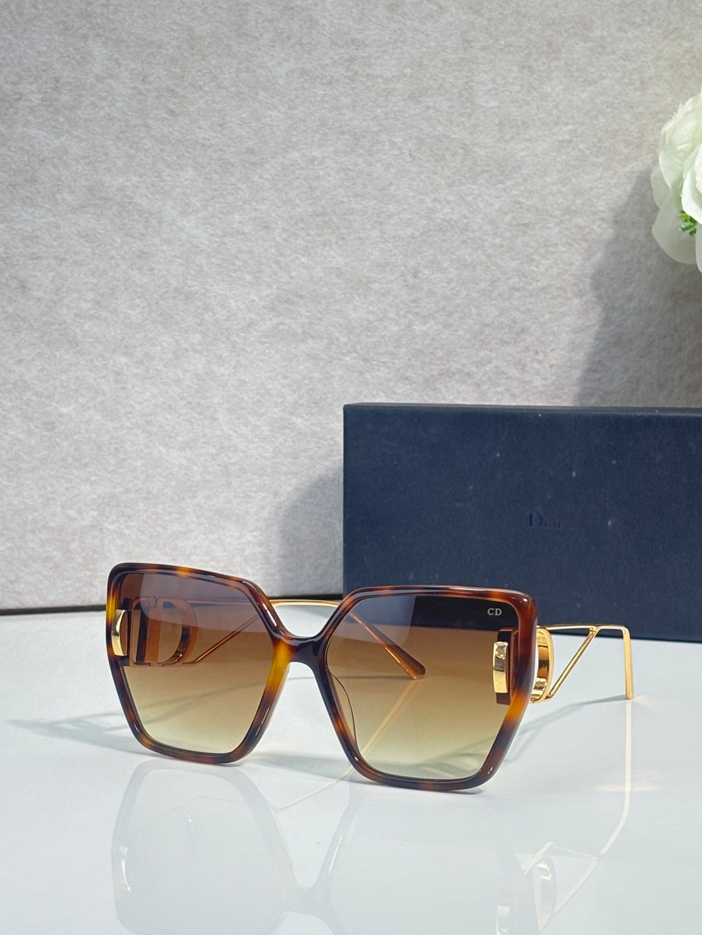 Dior sunglasses with tortoiseshell frames and amber square tinted lenses