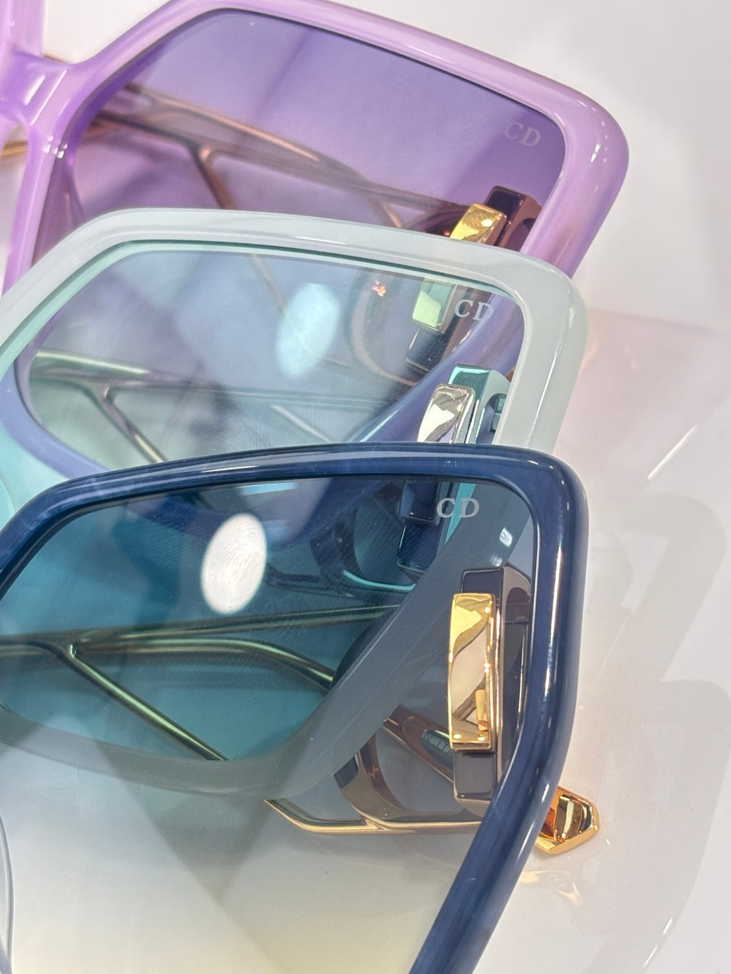 Dior sunglasses close-up: layered frames with gold trim and tinted lenses