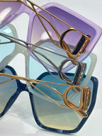 Dior sunglasses close-up: purple frame with gold accents and tinted lens