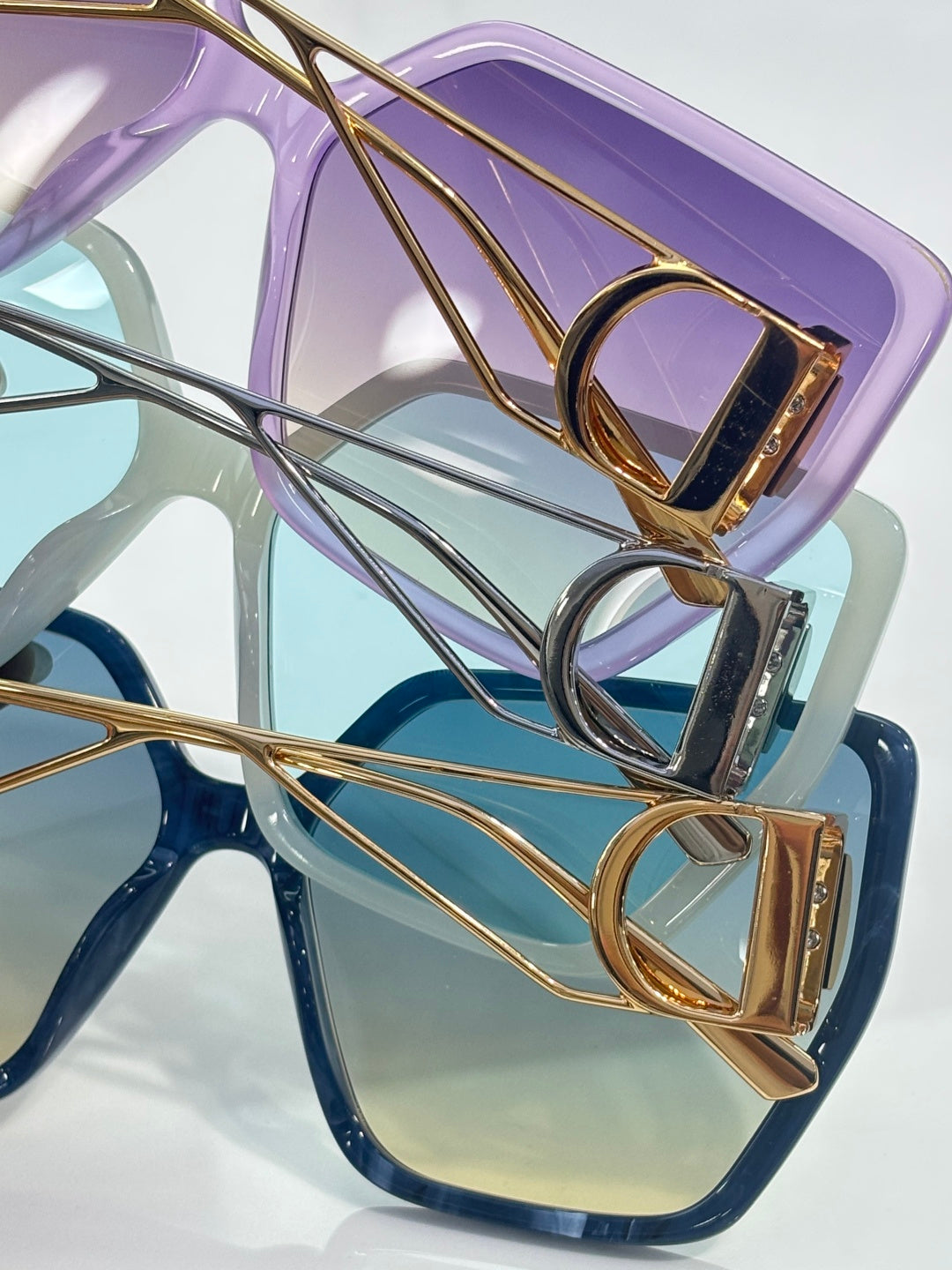 Dior sunglasses close-up: purple frame with gold accents and tinted lens
