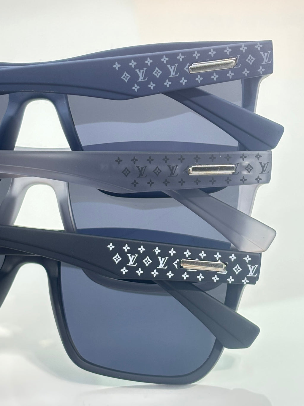 Louis Vuitton sunglasses with navy frames and LV monogram patterned temples