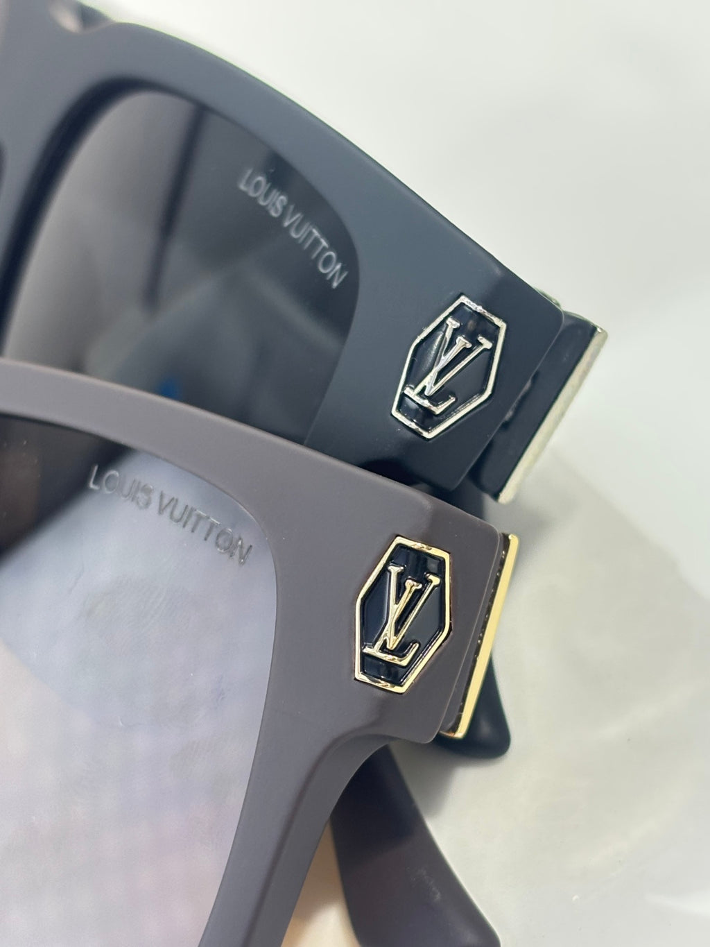 Louis Vuitton sunglasses temple close-up with LV emblem on dark gray frame