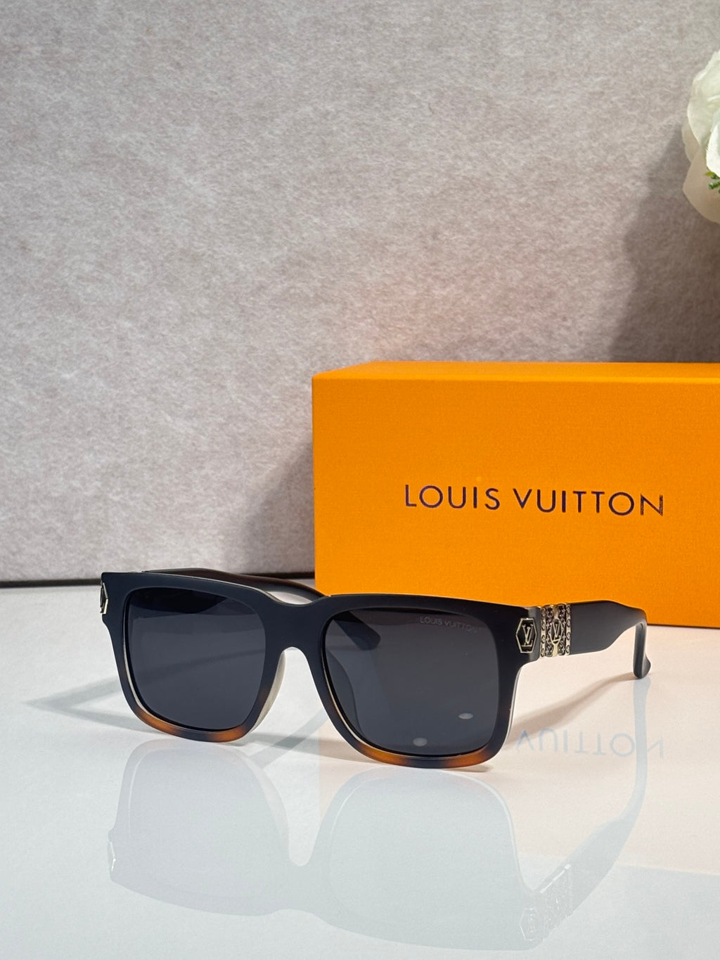 Louis Vuitton sunglasses with dark gray frames and black tinted lenses, side logo detail