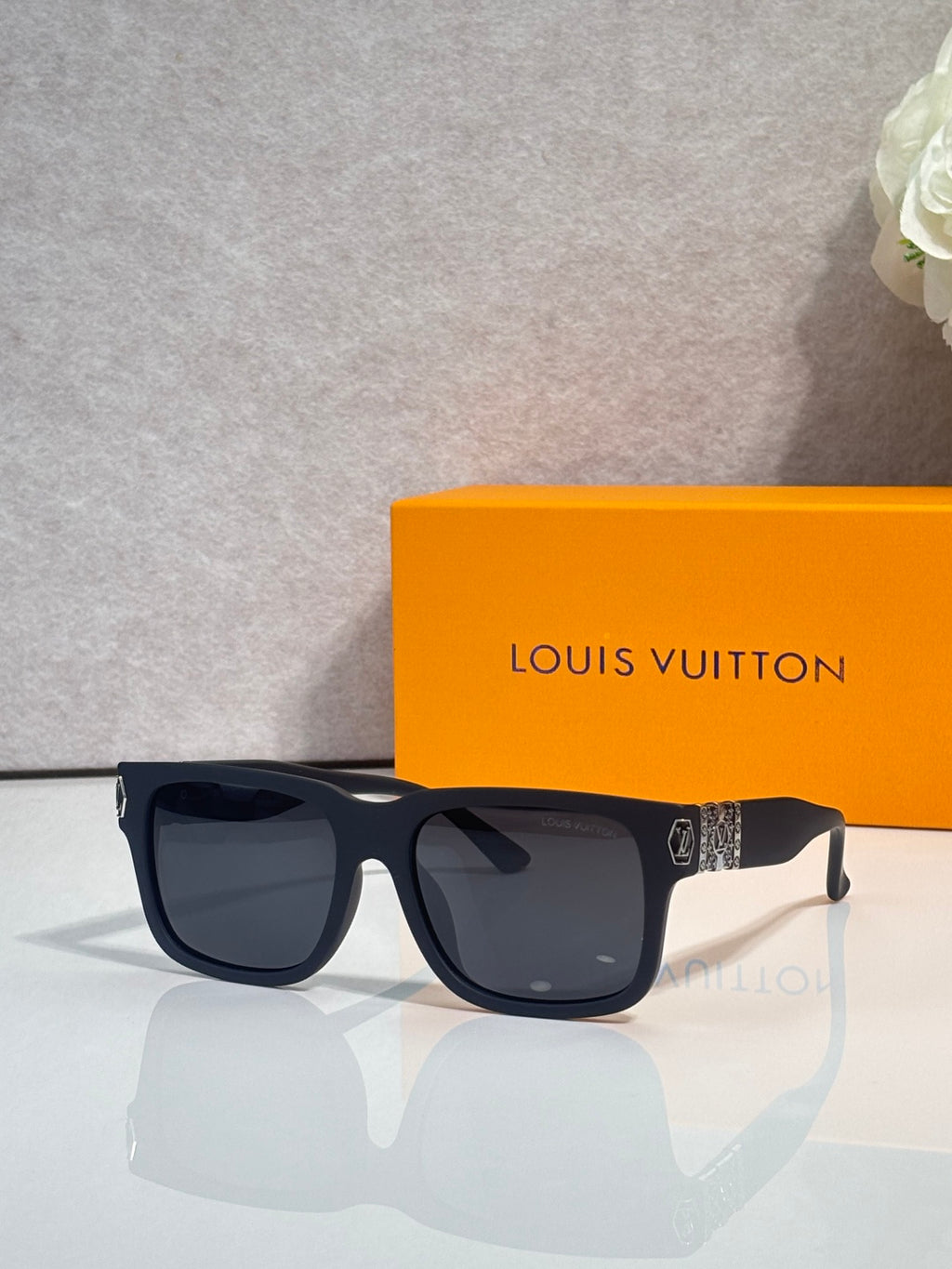 Louis Vuitton sunglasses with dark gray frames and black tinted lenses, front view