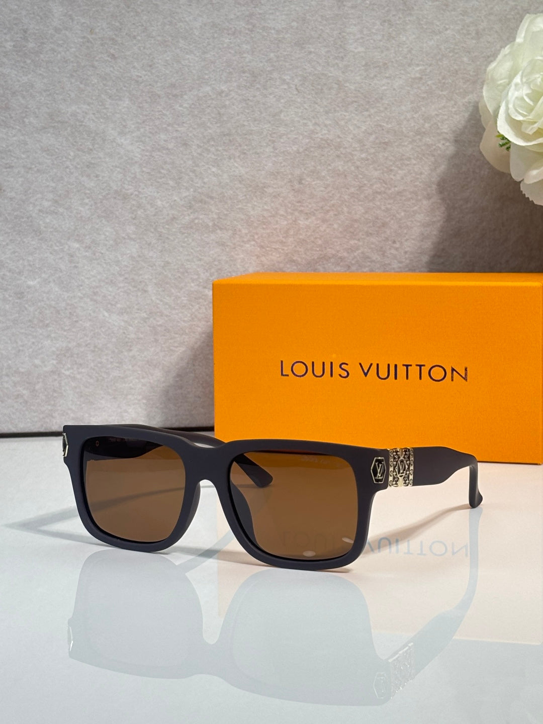 Louis Vuitton sunglasses with dark gray frames and brown tinted lenses