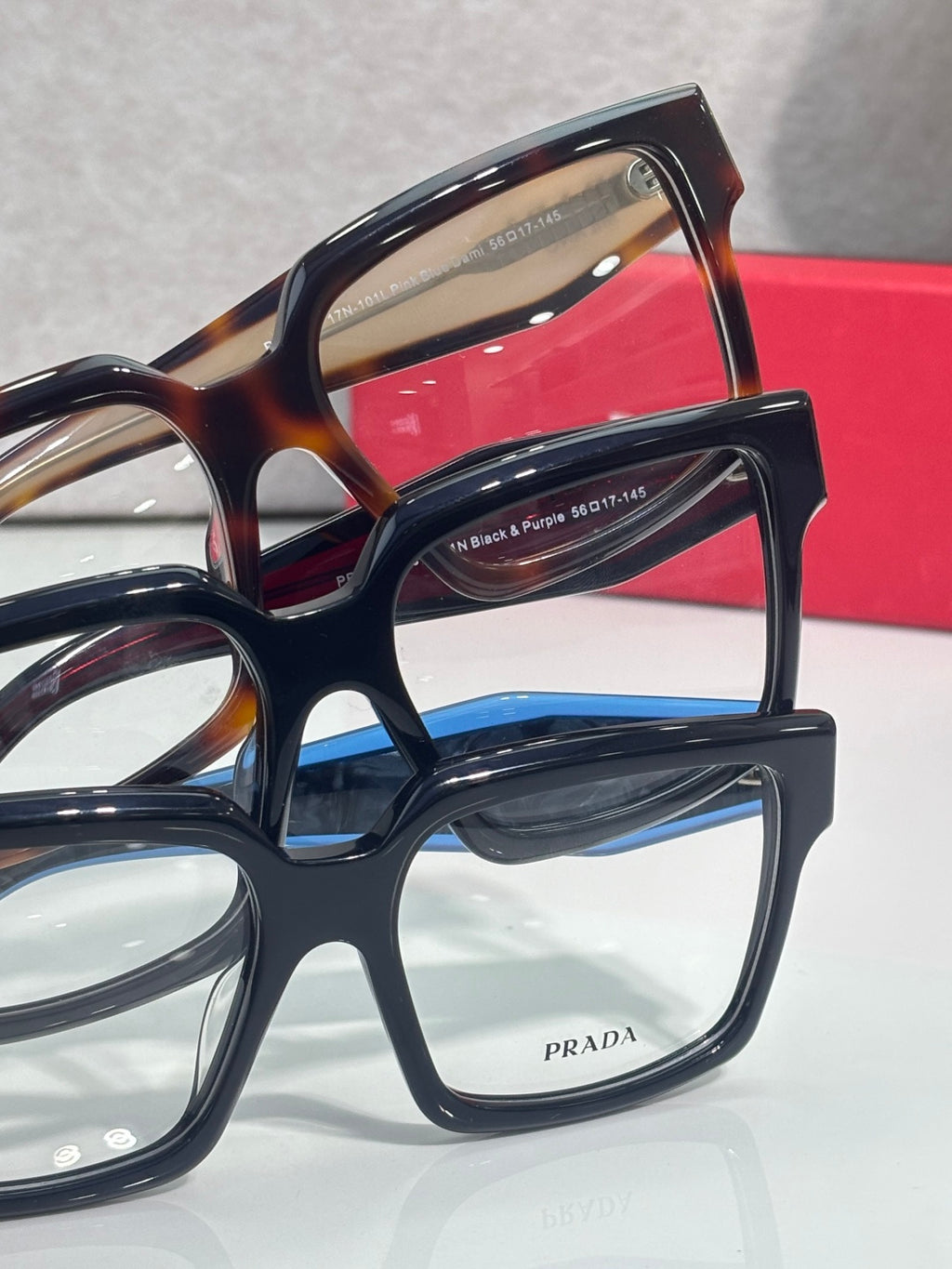 Prada rectangular eyeglasses close-up with dark blue and tortoise frames