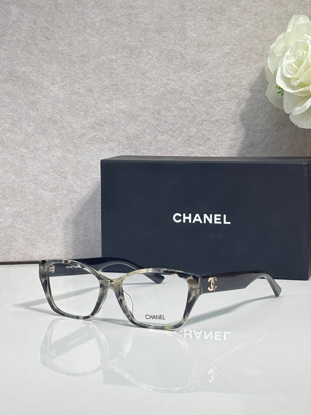 Gray-tortoise eyeglasses with square lenses, CHANEL logo on side, full frame.