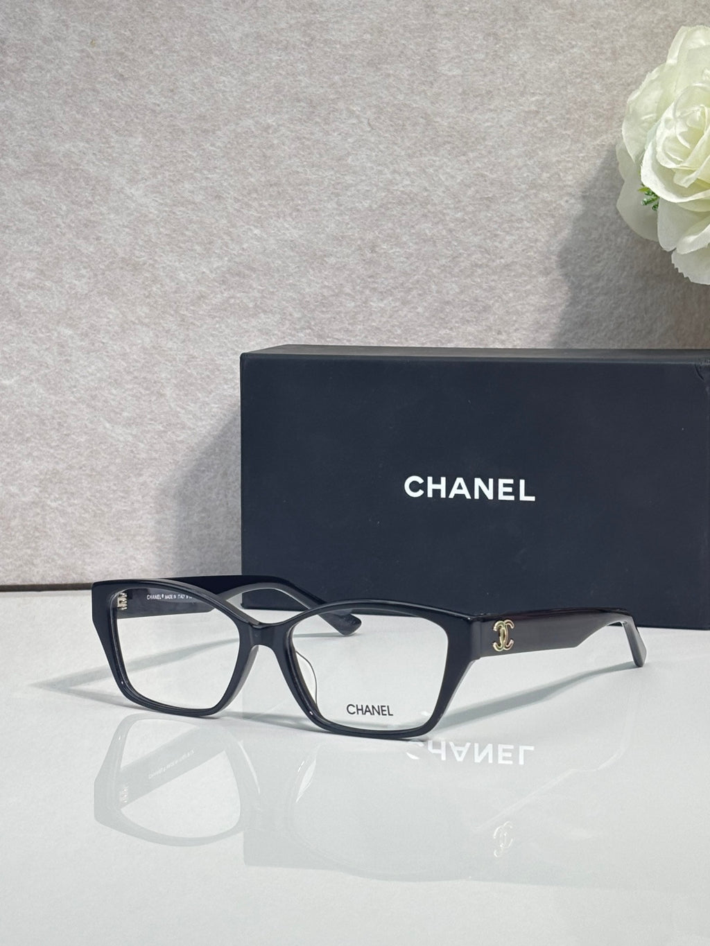 Dark navy eyeglasses with rectangular lenses and CHANEL logo at temple, full frame.