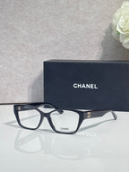Black eyeglasses with square lenses and CHANEL logo on temple, full frame.