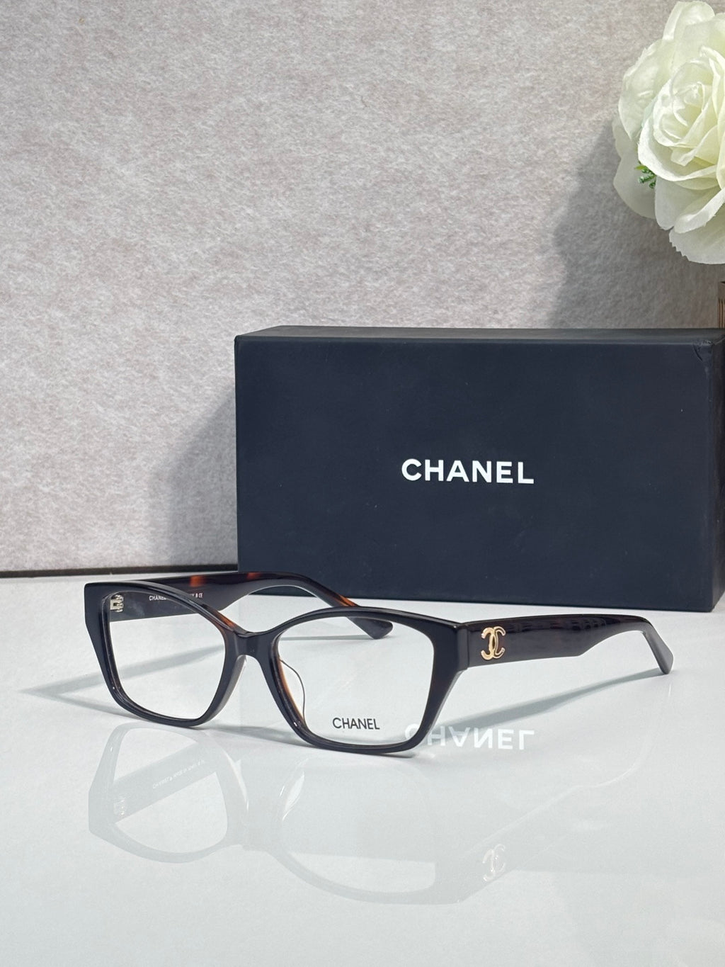 Chanel eyeglasses, dark frames with leopard-print temples and clear lenses