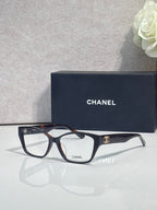 Chanel eyeglasses, dark frames with leopard-print temples and clear lenses