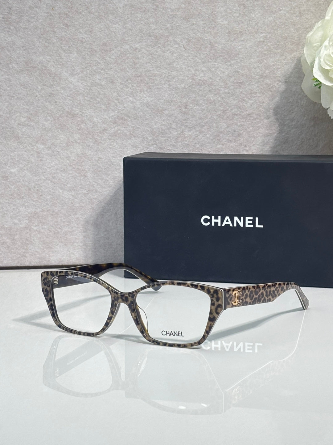 Chanel eyeglasses with dark frames and leopard-print temples, clear lenses