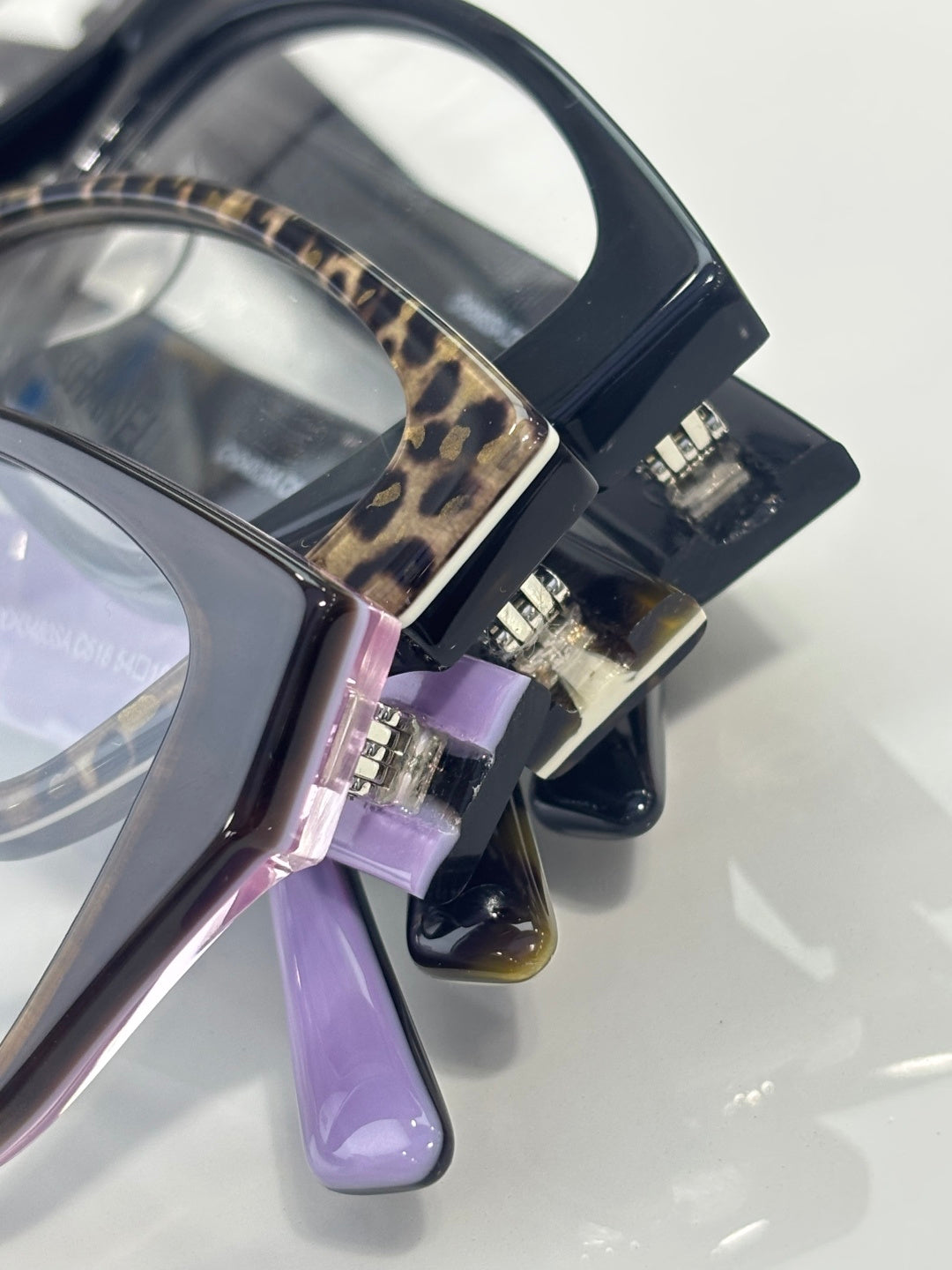 Chanel eyeglasses hinge detail with dark frame, leopard inlay, and purple temple