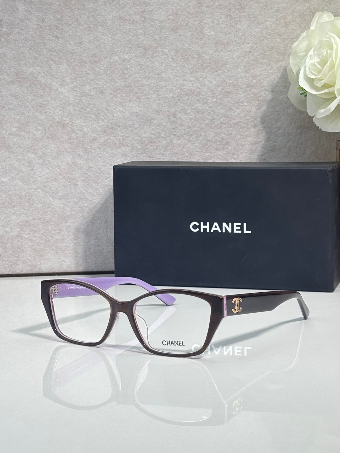 Chanel eyeglasses with dark frames, leopard-print temples, light purple-tinted lenses
