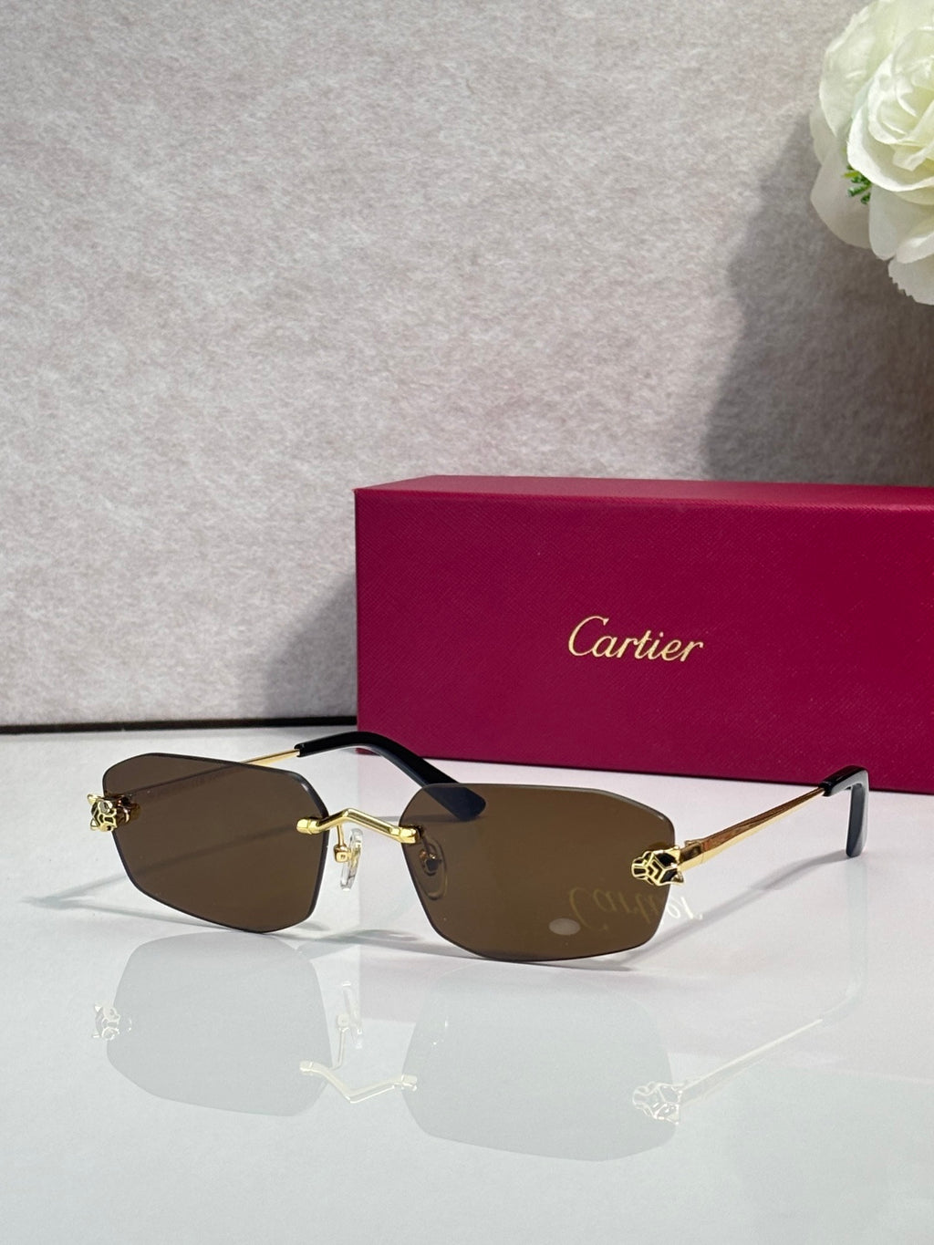 Cartier sunglasses with gold frame, dark brown lenses, black temple tips