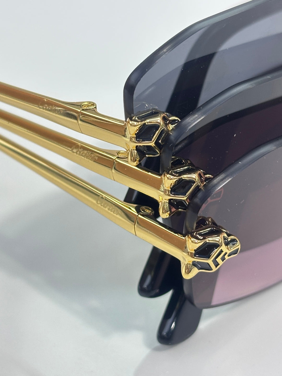 Cartier sunglasses hinge close-up with gold frame and dark lens