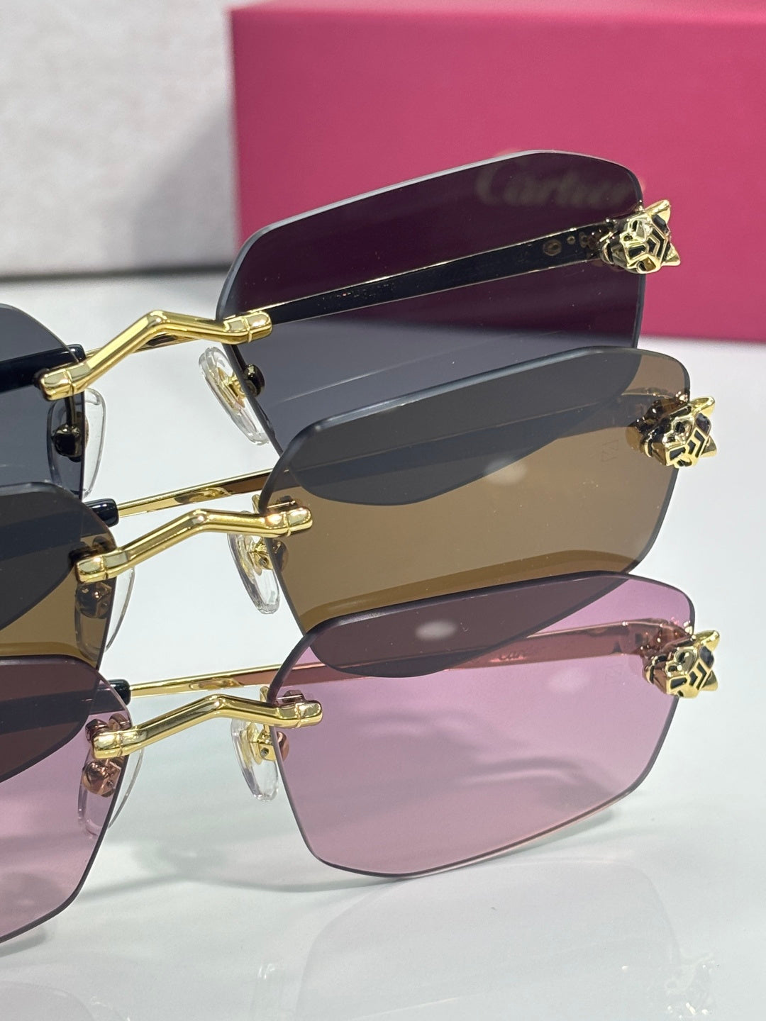 Cartier sunglasses close-up of gold frame tips with multiple colored lenses