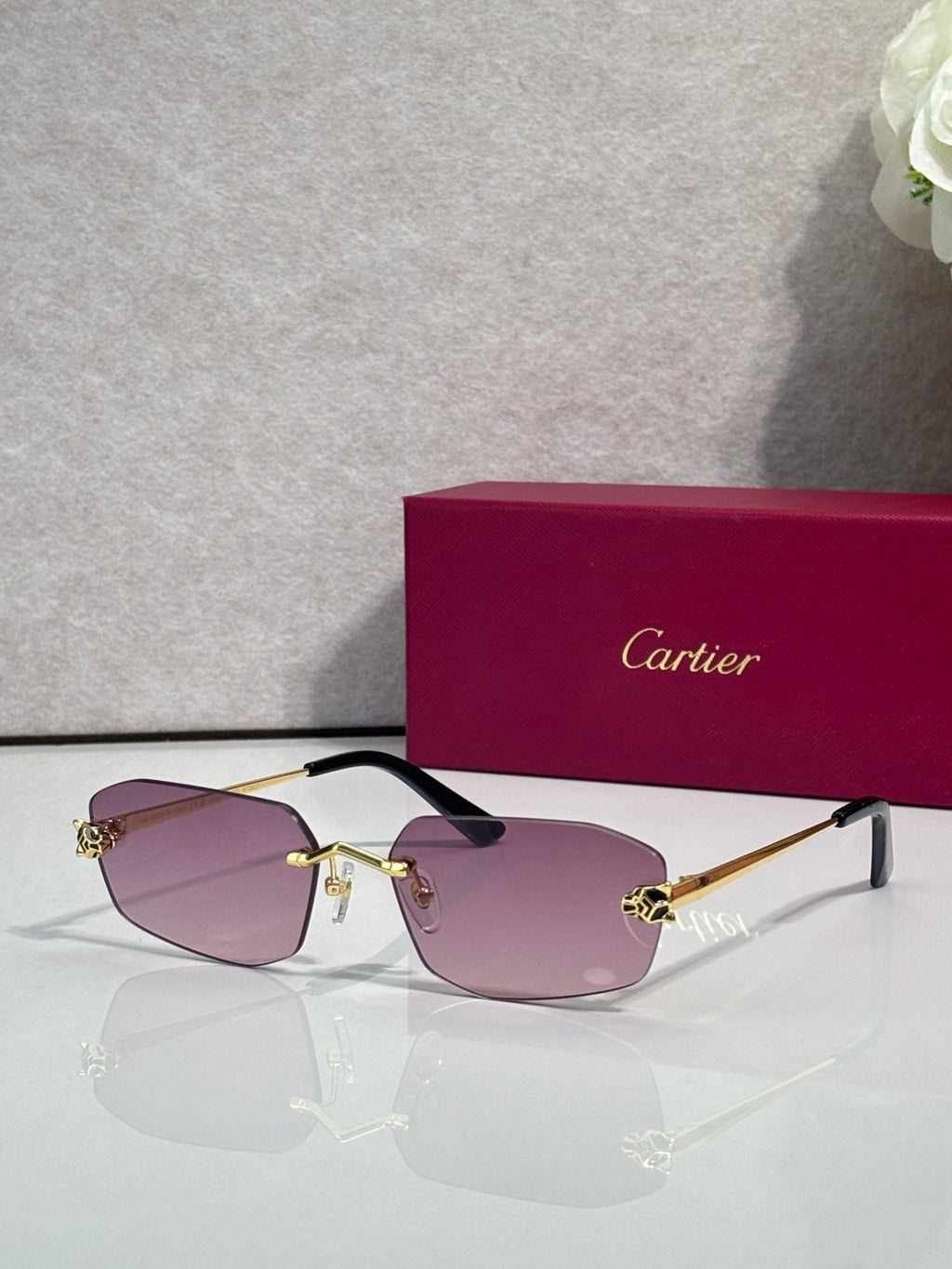 Cartier sunglasses with gold frame, light pink lenses, black temple tips
