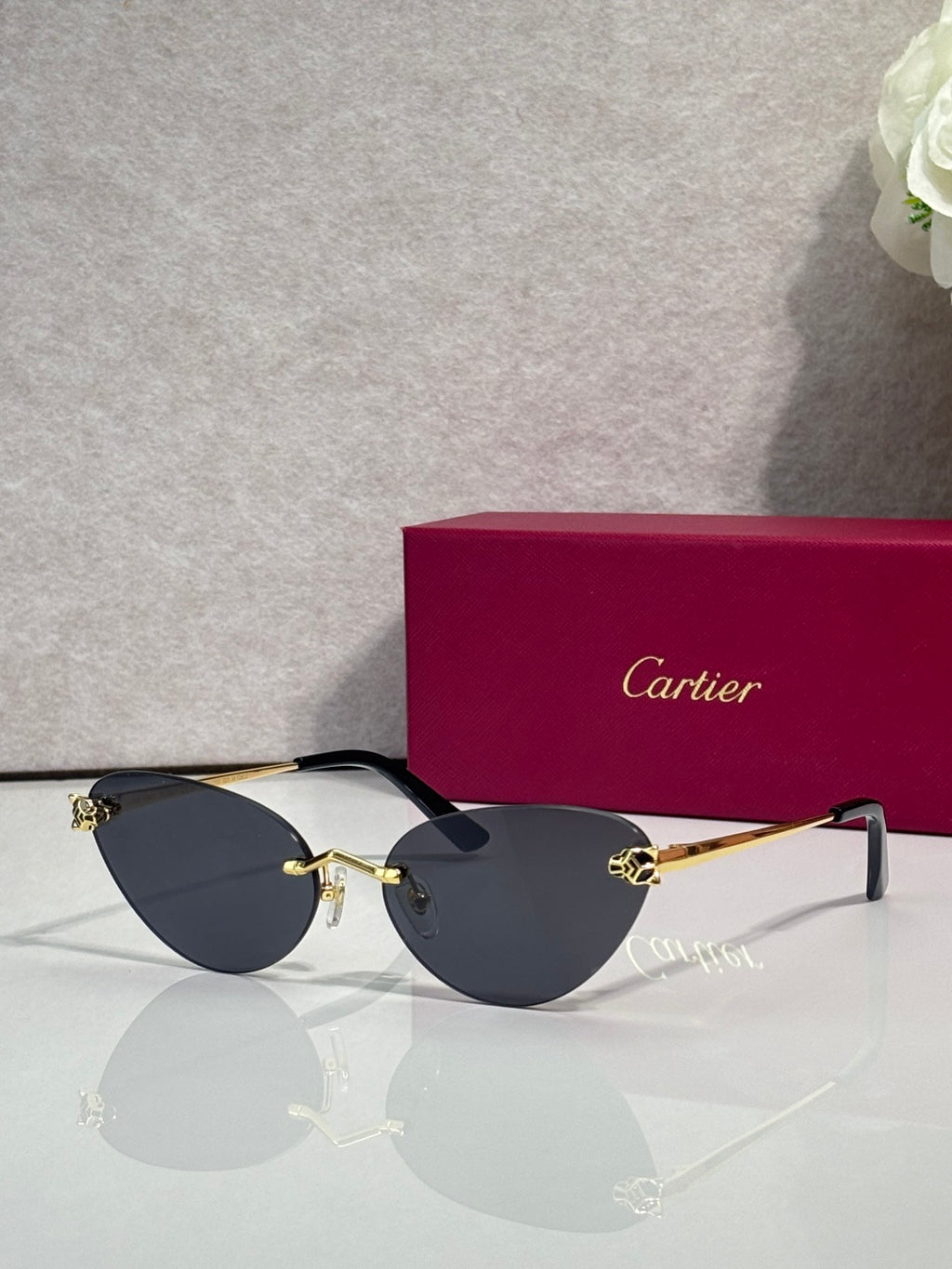 Cartier glasses with gold frame, dark lenses, and black temples