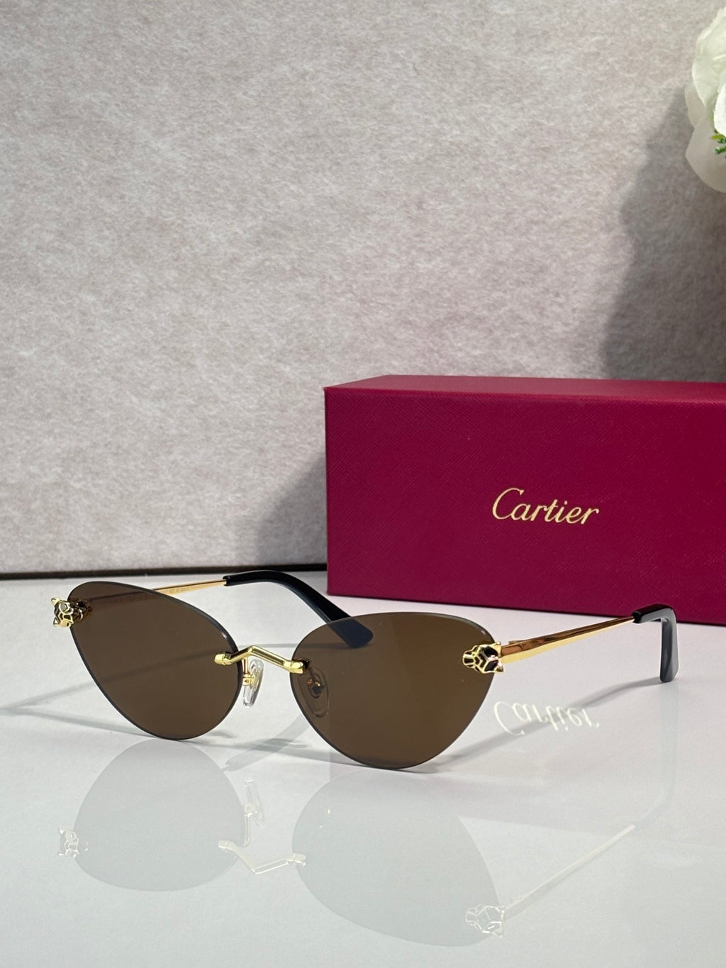 Cartier glasses with gold frame, dark brown lenses, and black temples
