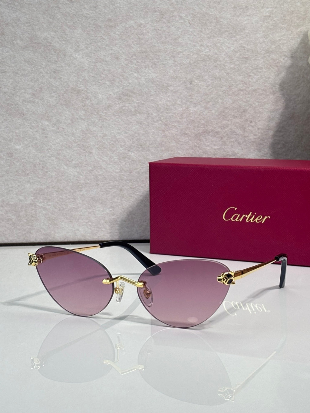 Cartier glasses with gold frame, purple lenses, and black temples