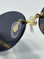 Cartier round sunglasses close-up: gold detail on dark lens and temple