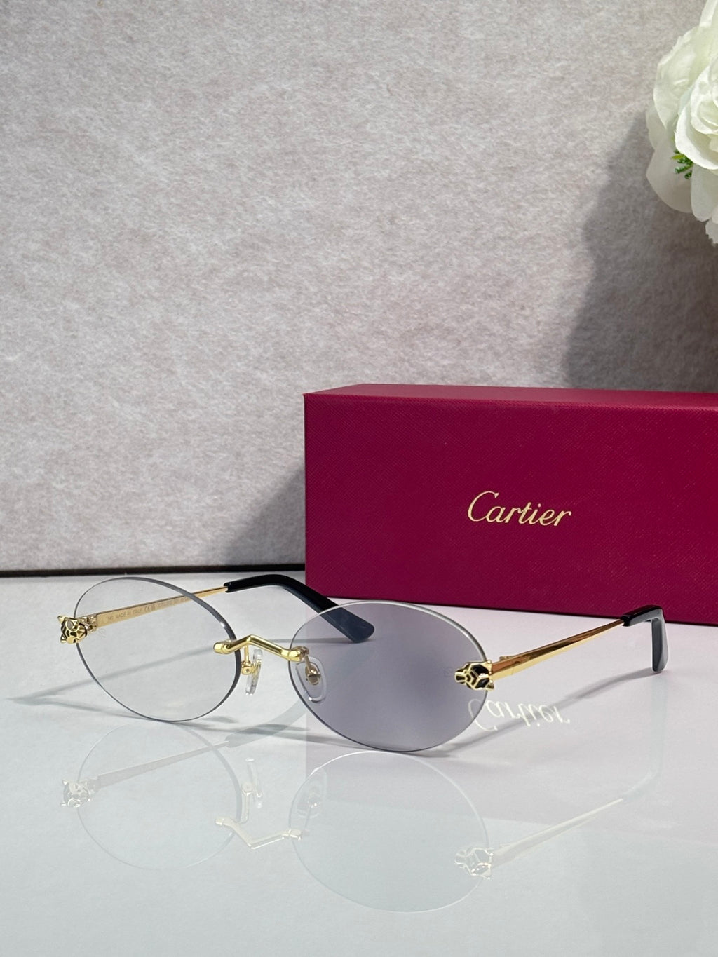 Cartier round sunglasses with clear frames, gold temples, gray tint lenses