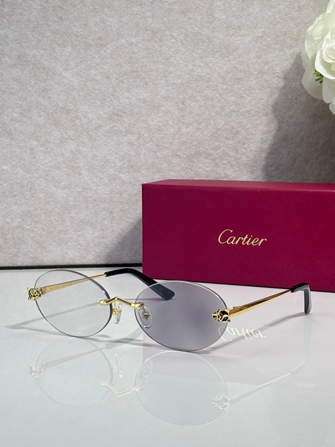 Cartier round sunglasses with clear frames, gold temples, gray tint lenses