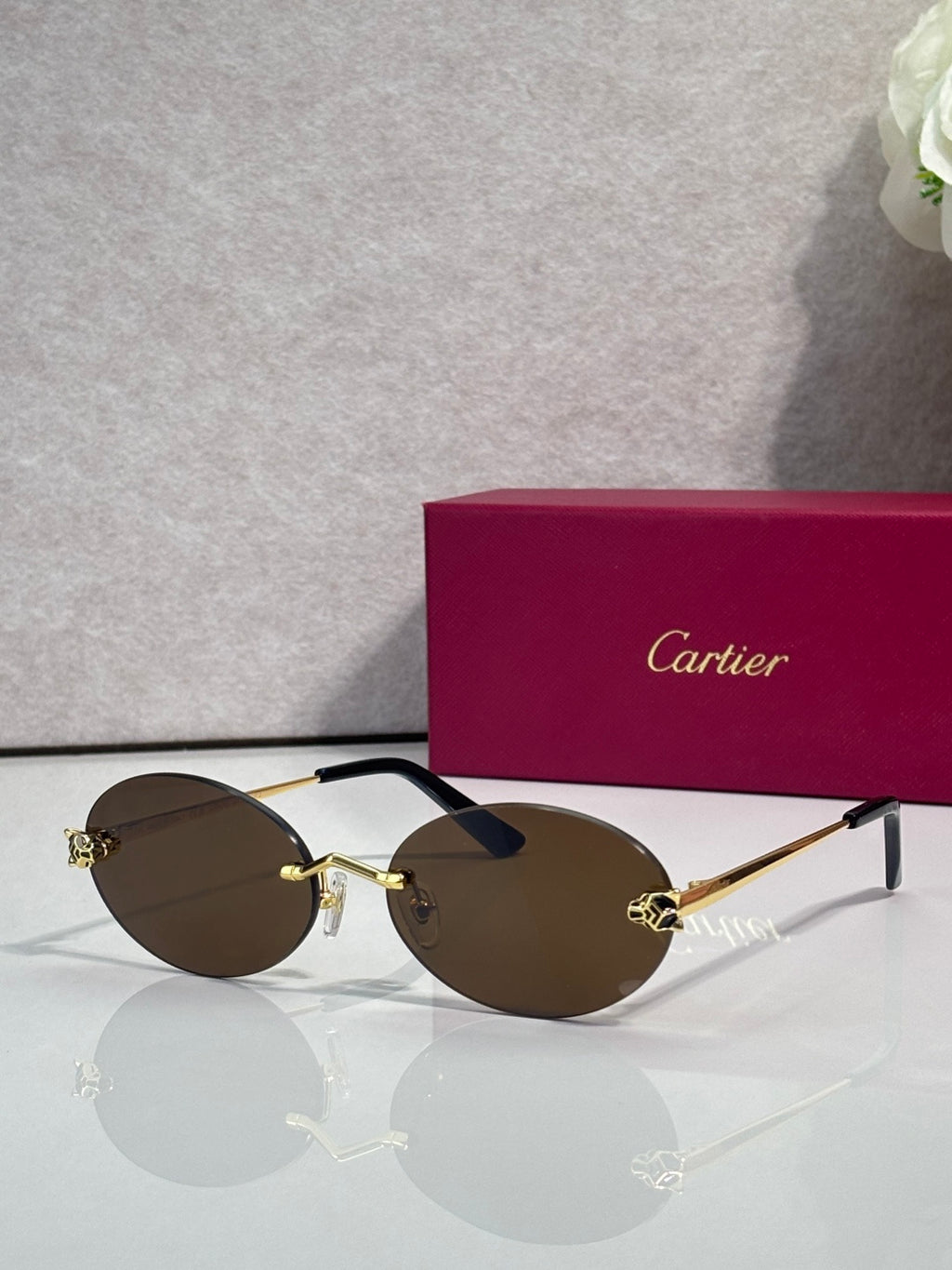 Cartier round sunglasses with clear frames, gold temples, brown tint lenses