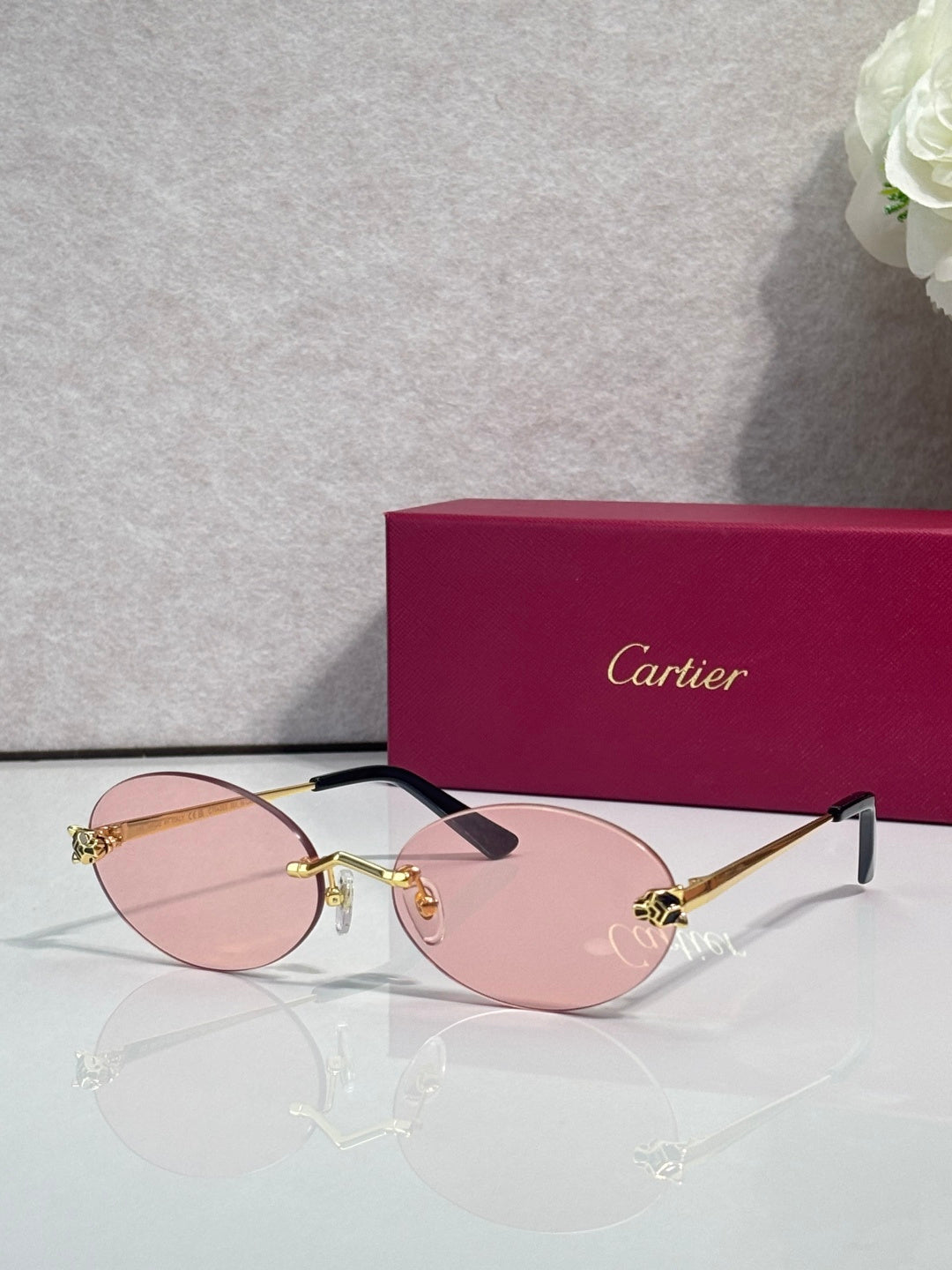 Cartier round sunglasses with clear frames, gold temples, pink tint lenses