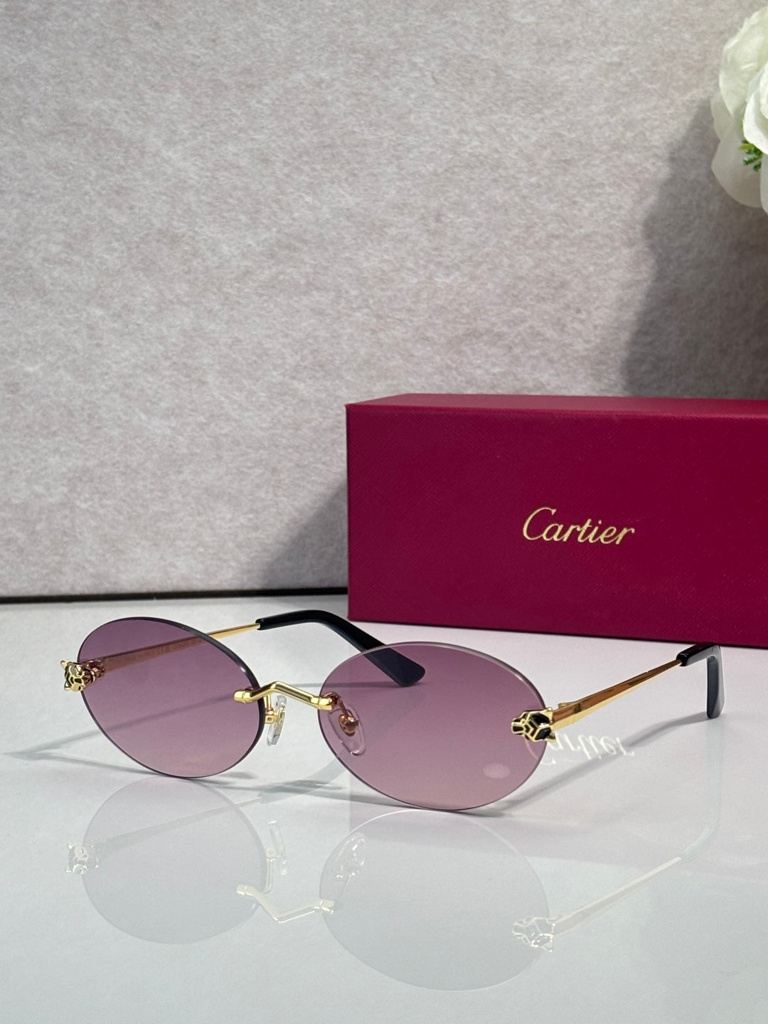 Cartier round sunglasses with clear frames, gold temples, purple tint lenses
