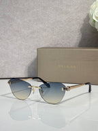 Sunglasses with blue gradient lenses, black frame, and gold metal accents